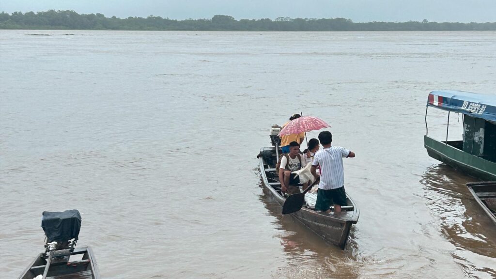 Locals arriving by boat at the starting point of an Ayahuasca jungle retreat near Iquitos