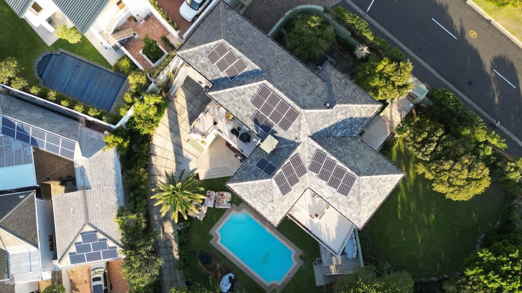 Luxury villa in Cape Town with solar panels and private pool, viewed from above — showcasing affordable upscale living in South Africa