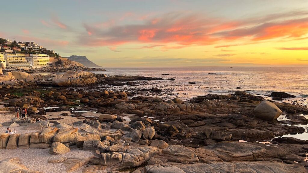 Scenic sunset over Cape Town’s Clifton coastline with rocky beach and ocean view