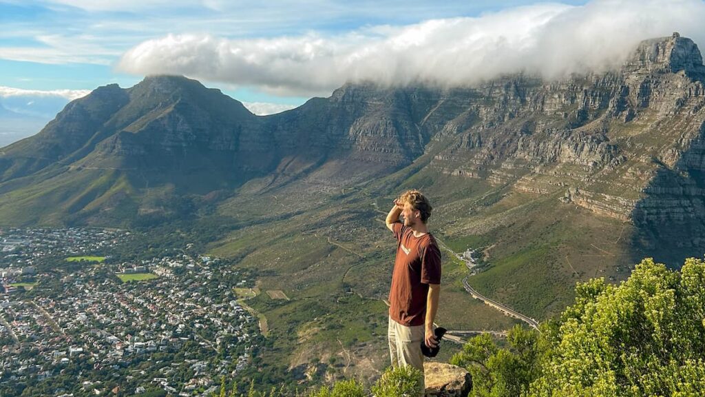 Digital nomad overlooking Cape Town from a mountain viewpoint with Table Mountain in the background, highlighting affordable luxury travel and cost of living in South Africa