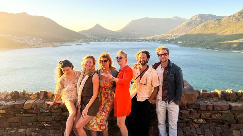 Group of friends enjoying sunset views over Hout Bay near Cape Town, showcasing the vibrant social life of digital nomads in South Africa"