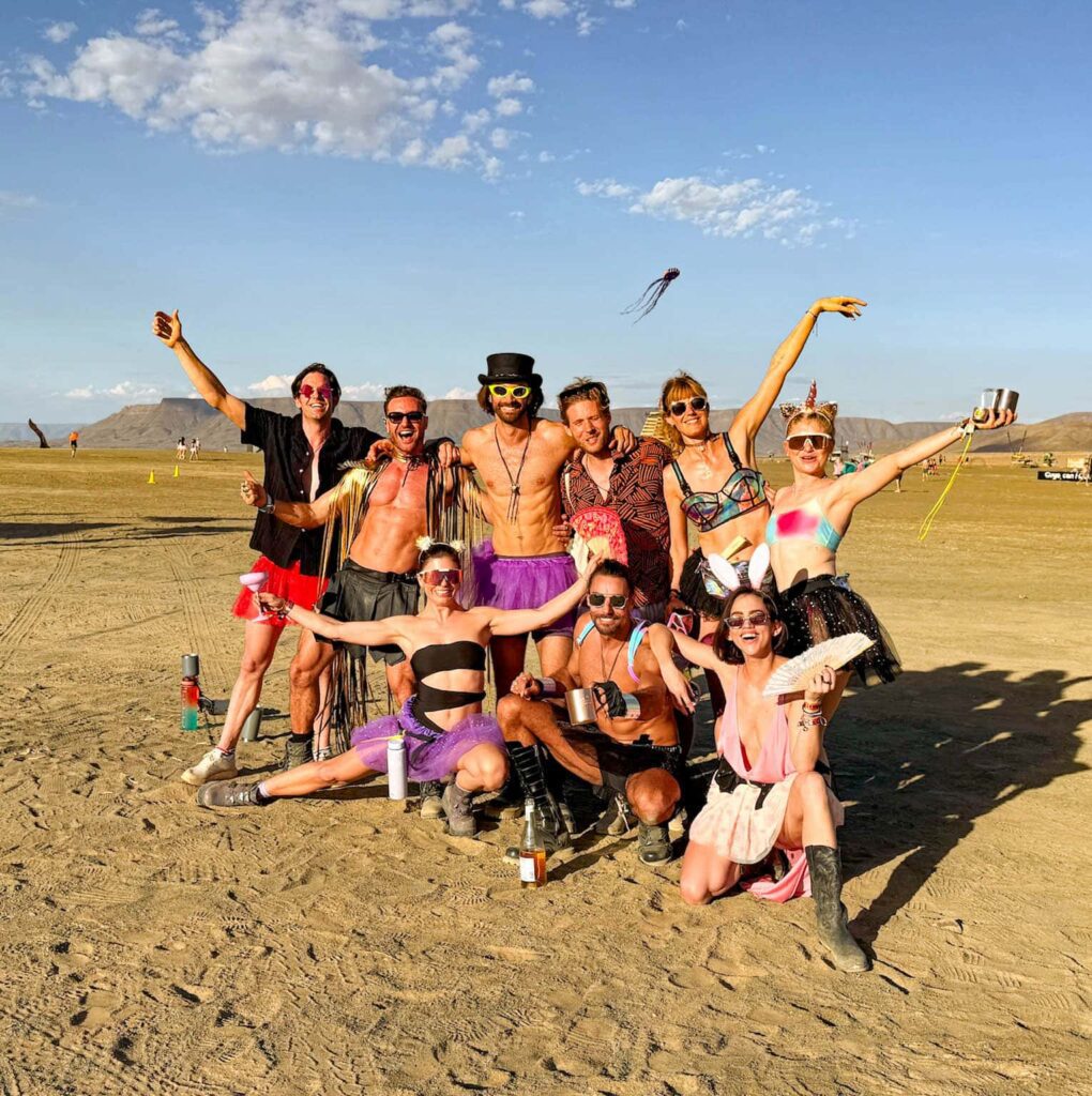 Group of friends in colorful costumes celebrating at AfrikaBurn festival in South Africa — embracing creativity, community, and freedom